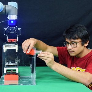 A human, USC Viterbi graduate student Prahar Bhatt, and a robot, a mobile manipulator developed by the Center for Advanced Manufacturing at USC. PHOTO/ARIYAN KABIR.