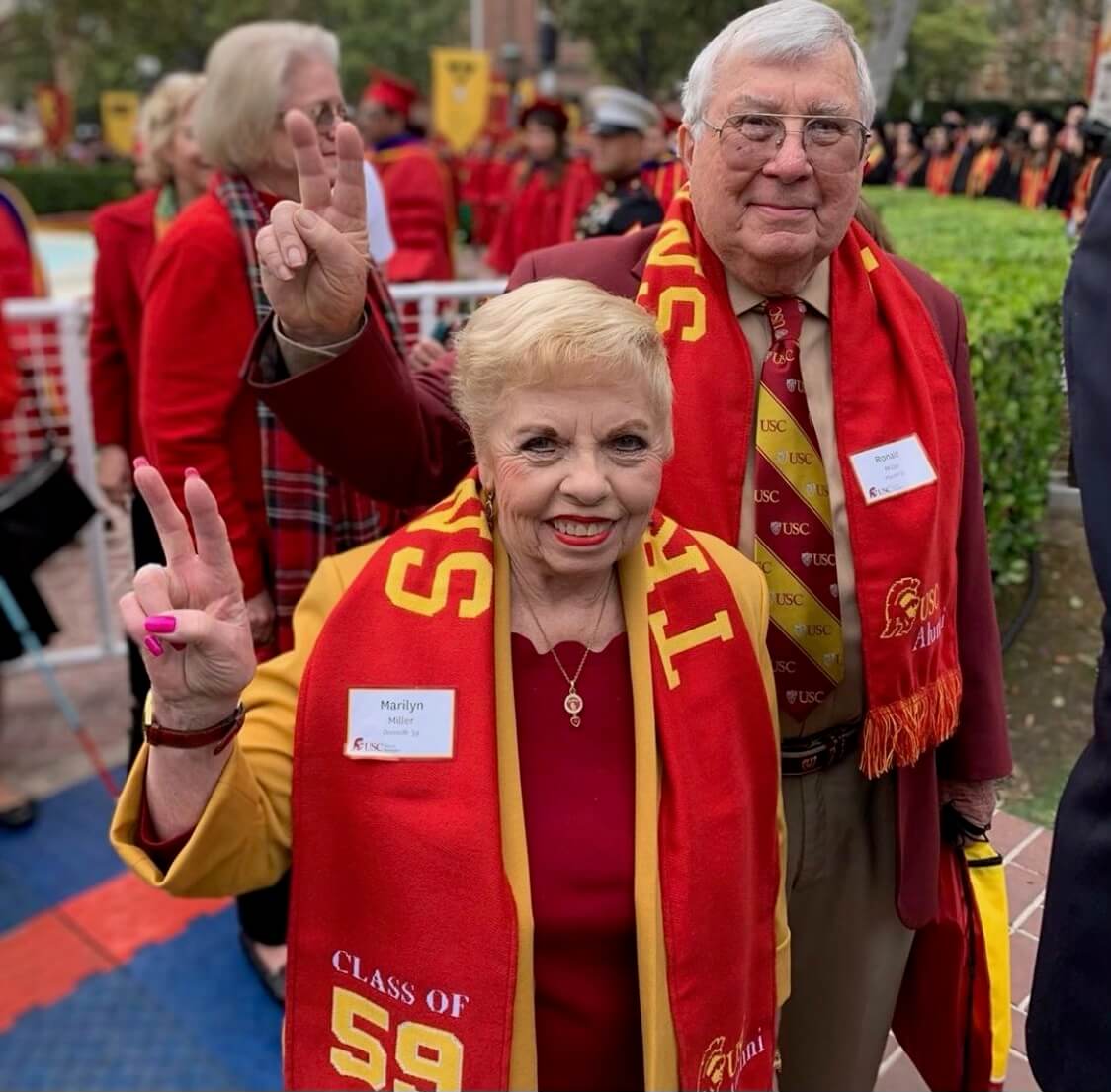 Marilyn and Ronald Miller - USC alumni - at a USC ceremony on campus making fight on symbol 