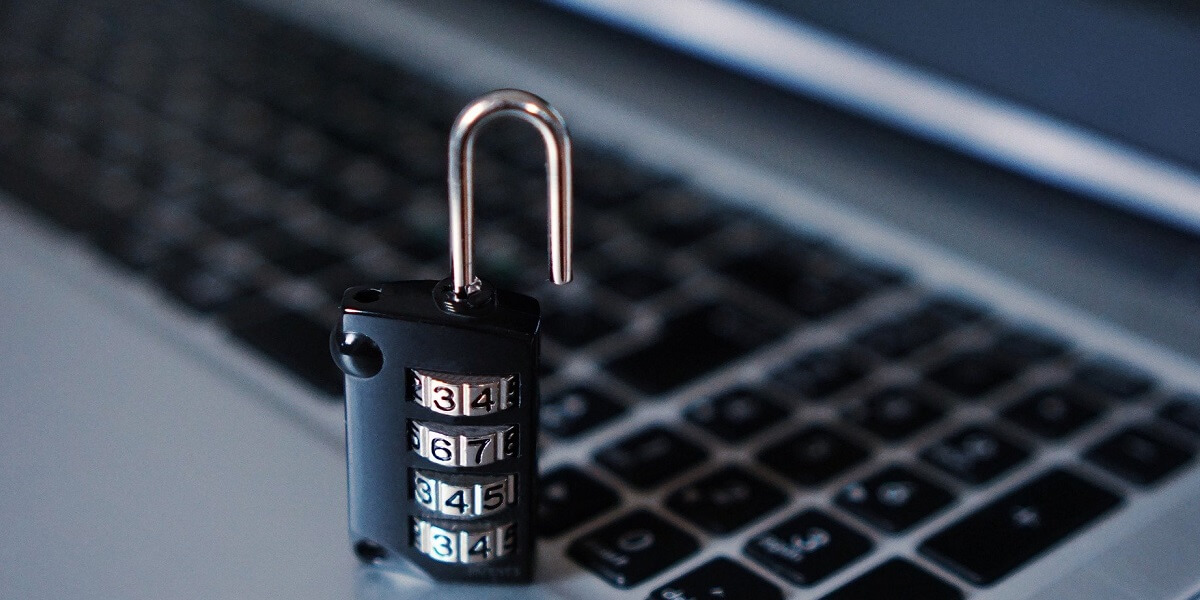 Picture of an open lock by a laptop keyboard, symbolizing the need for cybersecurity
