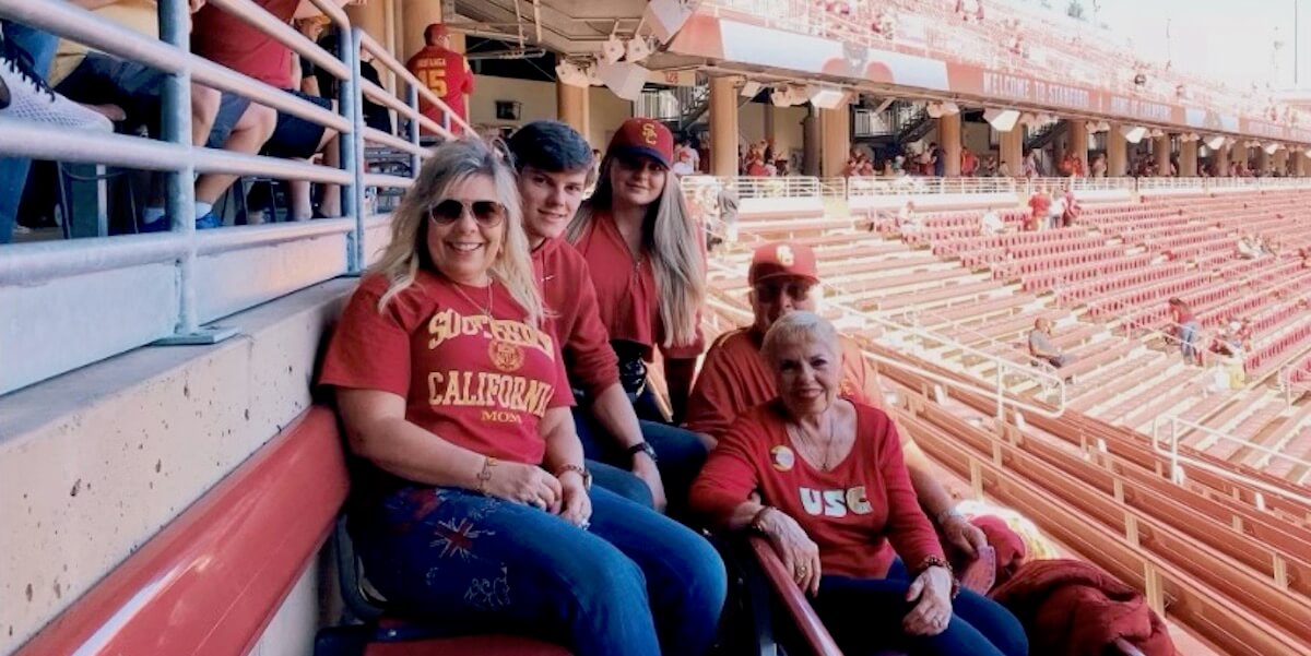 Three generations of a Trojan family in the bleachers at a USC football game
