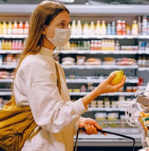 Woman shopping in a grocery store with mask on