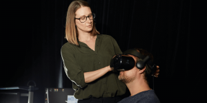 A demonstration of virtual reality goggles used to access the Virtual Interactive Training Agent platform. From left: Sharon Mozgai and Arno Hartholt. Photo credit: Justin Gilbert.