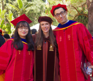 Professor Kelly Sanders, flanked by newly hooded Ph.D.s, Yun Li and Mo Chen, at the post hooding and awards reception in USC’s Associates Park.