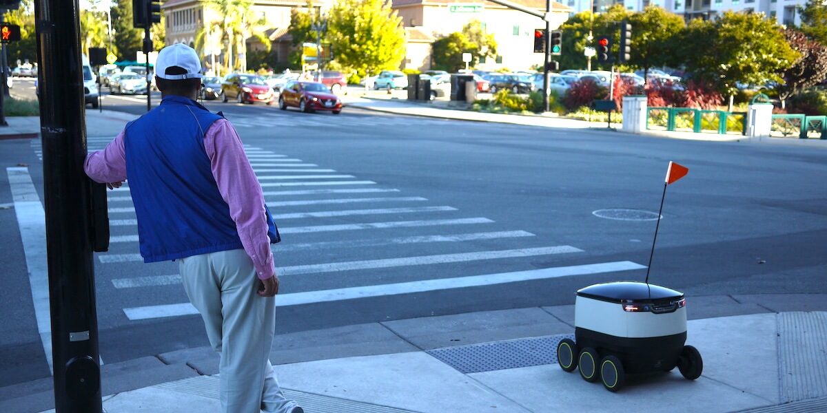 Man_and_delivery_robot_waiting_at_pedestrian_crosing_in_Redwood_City,_California