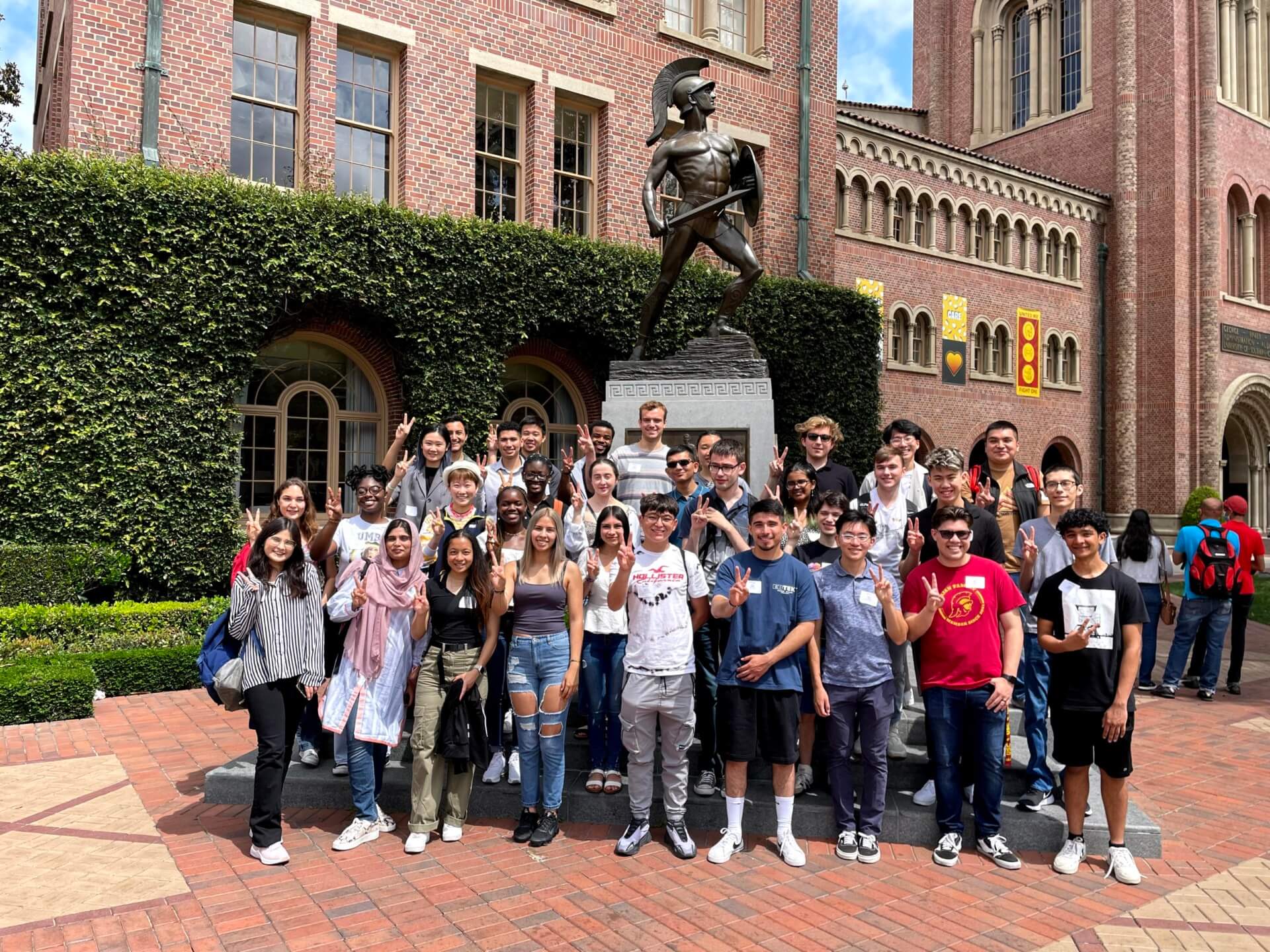 Sister2Sister Scholars (pictured on the far left, bottom row) visited the Tommy Trojan statue with their fellow exchange students.