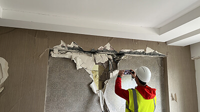 Dr. Gencturk investigating damage in a reinforced concrete beam between two shear walls. 