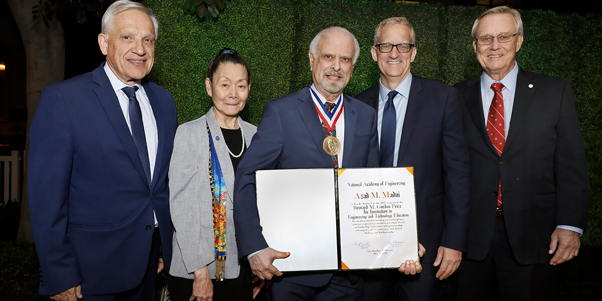 PROFESSOR AZAD MADNI ACCEPTS THE 2023 GORDON PRIZE. PICTURED FROM LEFT: DEAN YANNIS YORTSOS; DIANNE CHONG, CHAIR OF NAE GORDON PRIZE COMMITTEE; PROFESSOR AZAD MADNI; DEAN ANDREW GUZMAN; JOHN ANDERSON, PRESIDENT OF THE NATIONAL ACADEMY OF ENGINEERING.