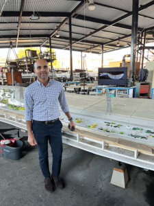 Luhar alongside the hydraulic model of the LA River installed in the City of Los Angeles’s Hydraulic Research Laboratory