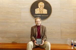 Donald Paul with a plaque to commemorate the new Donald L. Paul Chair in Energy and Technology Management