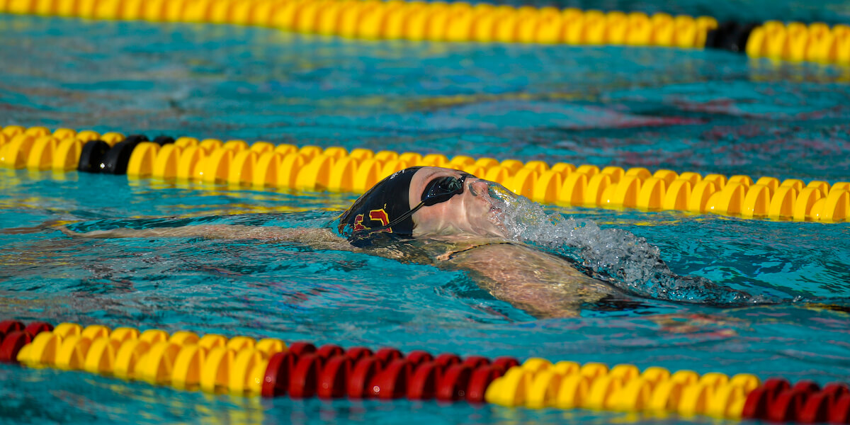 Aëla Janvier nadando espalda para la USC.  Imagen/Atletismo de la USC