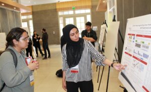 An image of Erum Mushtaq explaining her research during the poster-display session at the USC + Amazon Center Symposium on April 30, 2024.