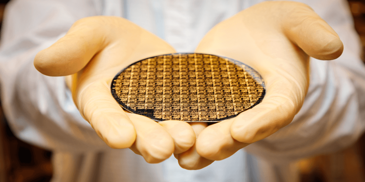 Photo of a semiconductor wafer in a person's hands.