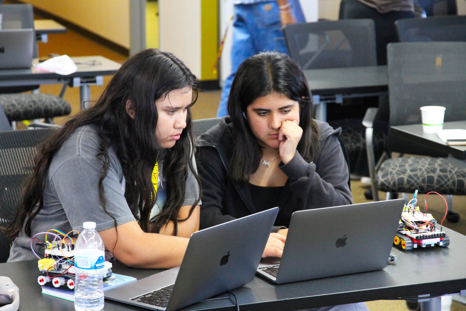 Two students work together on a laptop