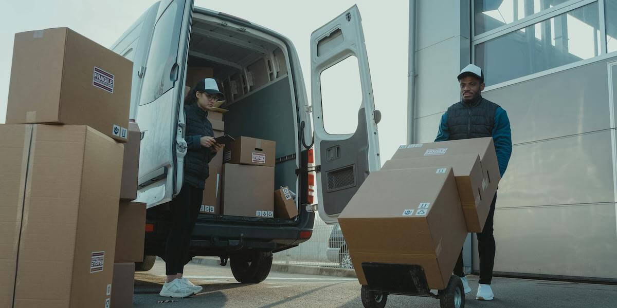 Delivery drivers dropping boxes at an address.