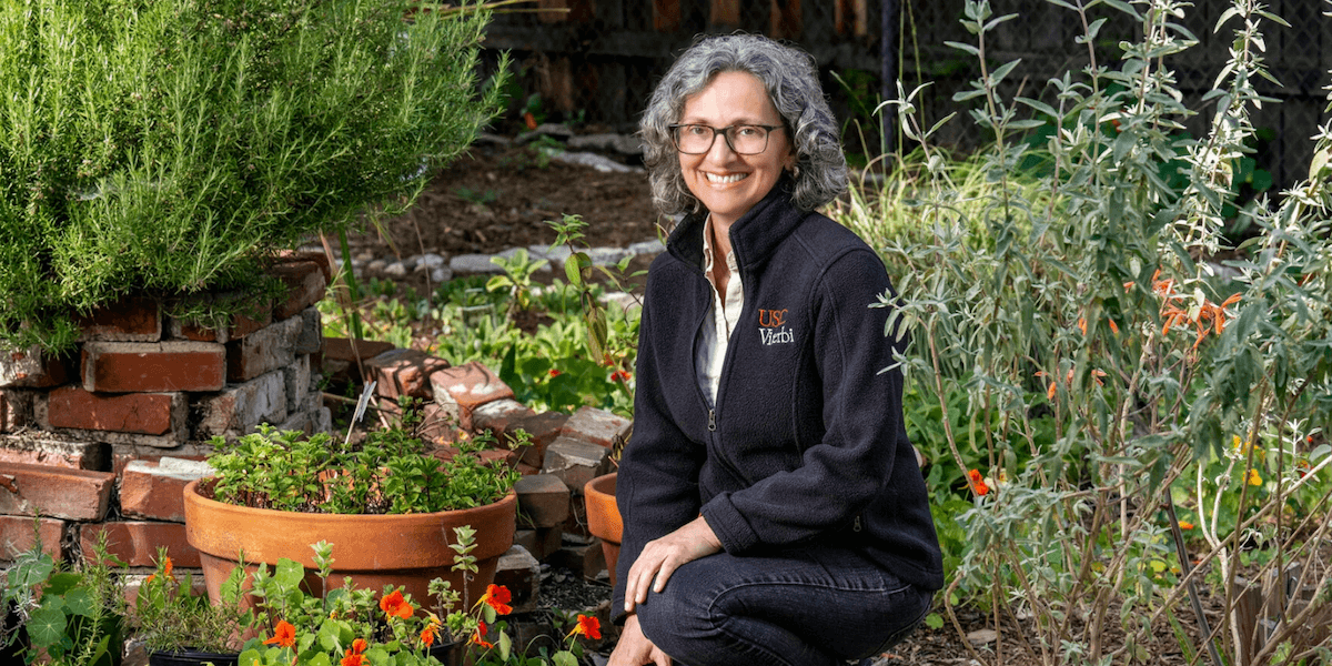 Mahta Moghaddam kneels in a garden