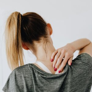 A woman experiencing shoulder and back pain.