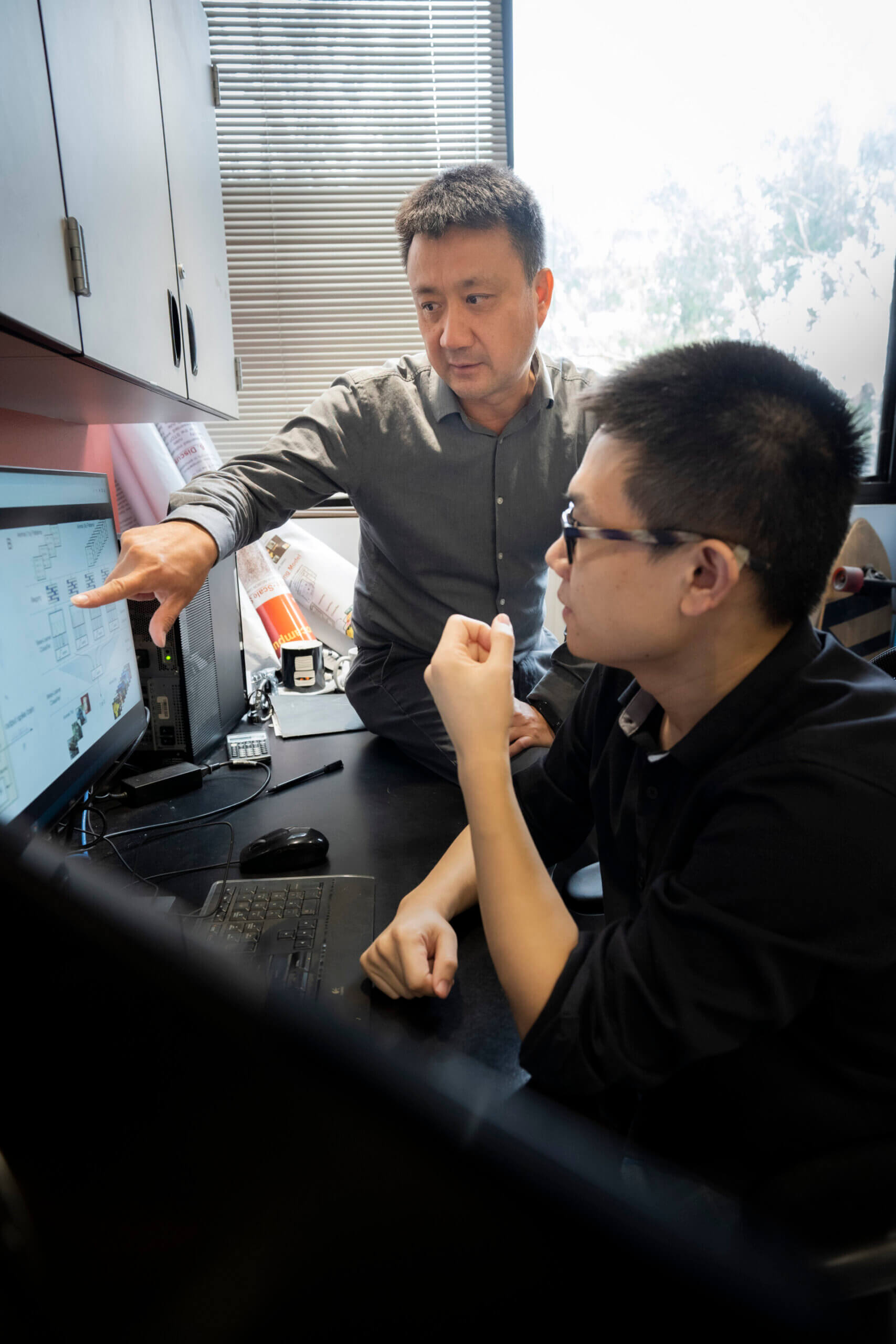Dong Song (L) and Xiwei She (R) discuss their machine learning model.