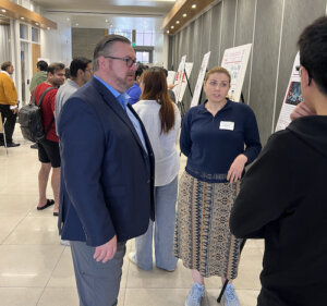Sean O’Brien, manager of programs for advanced autonomy at Northrop Grumman, discussing autonomy research with graduate students at the poster session (Photo/Courtesy of Maurena Nacheff-Benedict)